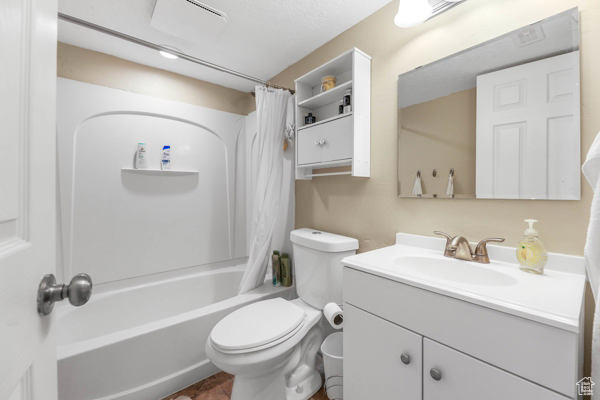 Bathroom featuring vanity, toilet, and shower / bath combination with curtain