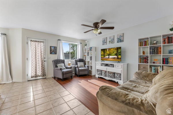 Living area featuring light tile patterned floors and ceiling fan