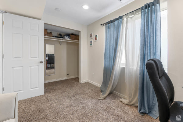 Bedroom with carpet, baseboards, recessed lighting, and a closet