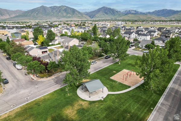 Aerial view of property and surrounding area with mountains and nearby suburban area