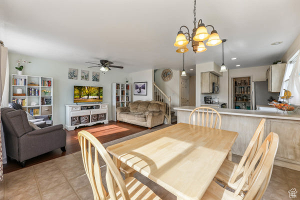 Dining room featuring stairway, a chandelier, light tile patterned floors, ceiling fan, and recessed lighting