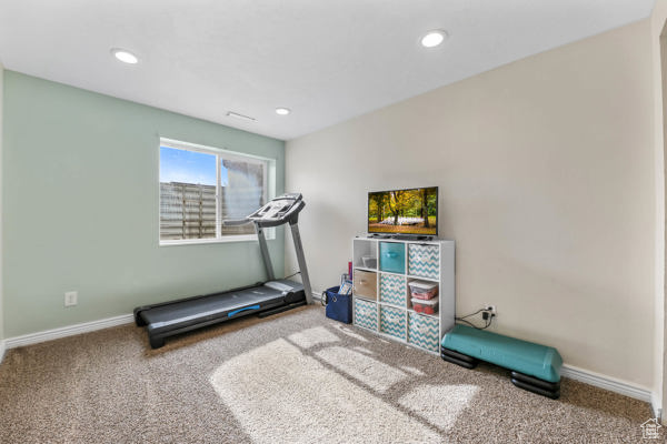 Exercise area featuring carpet floors, baseboards, and recessed lighting