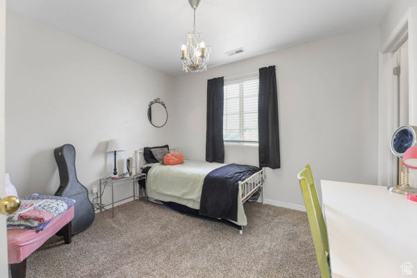 Carpeted bedroom with a chandelier