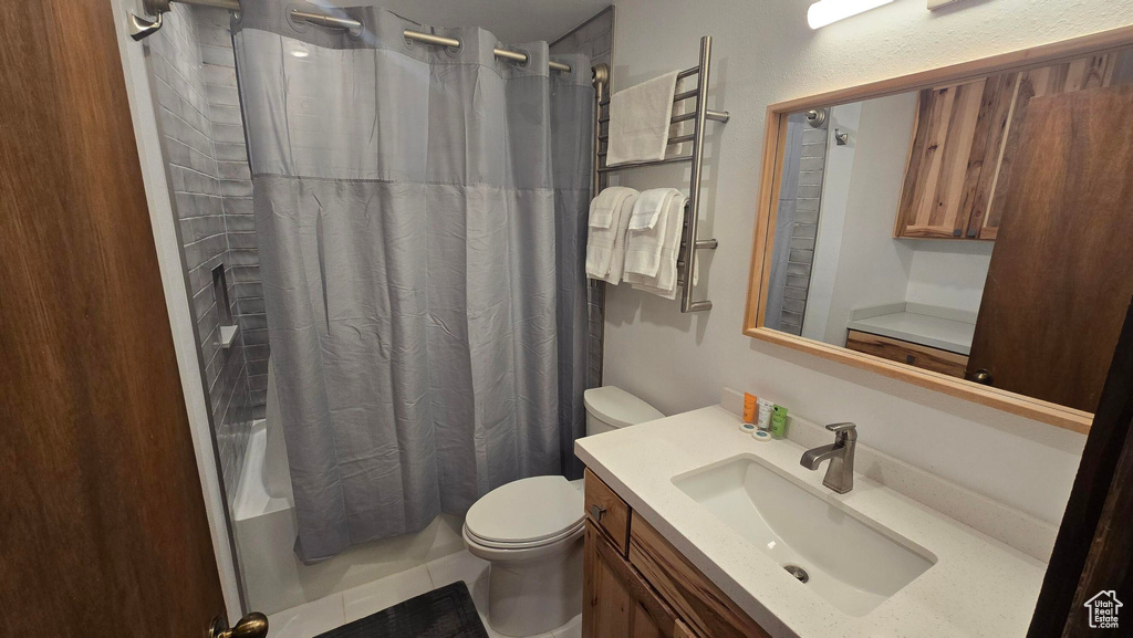Full bathroom featuring toilet, vanity, and shower / bath combo with shower curtain