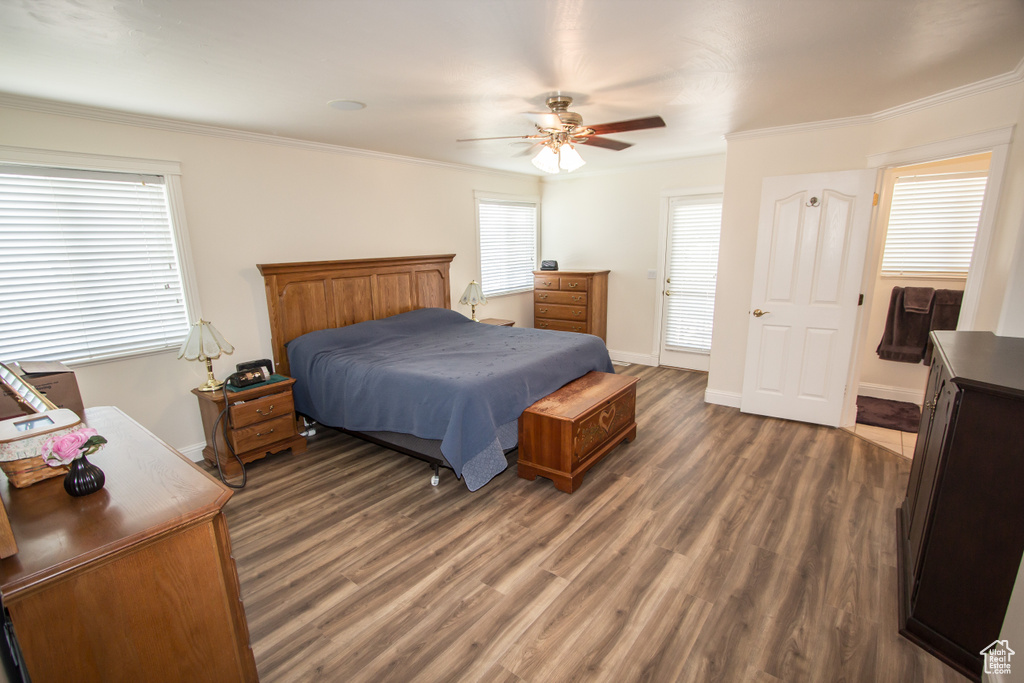 Bedroom with wood finished floors, crown molding, baseboards, and ceiling fan
