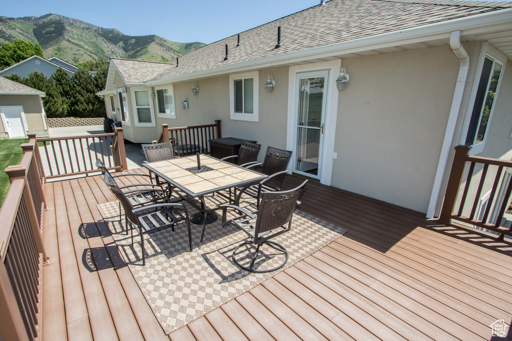 Wooden terrace with outdoor dining space and a mountain view