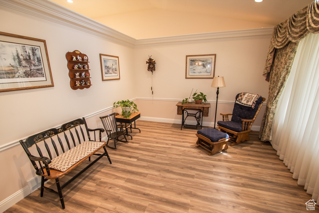 Living area featuring light wood-style flooring, recessed lighting, ornamental molding, baseboards, and lofted ceiling