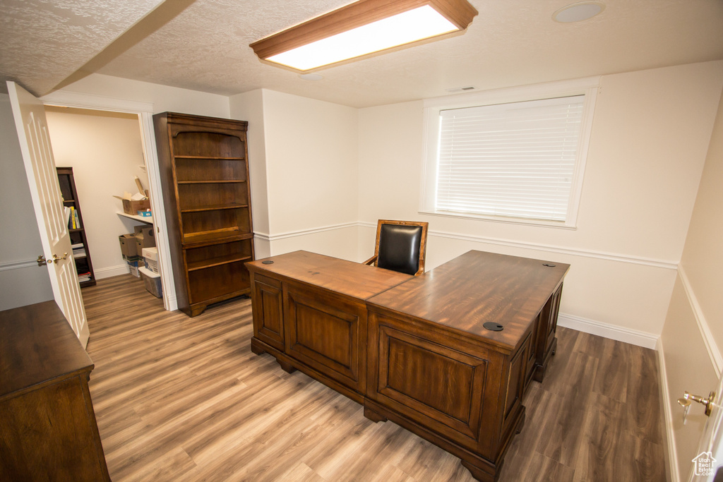 Office area with light wood-style floors and baseboards