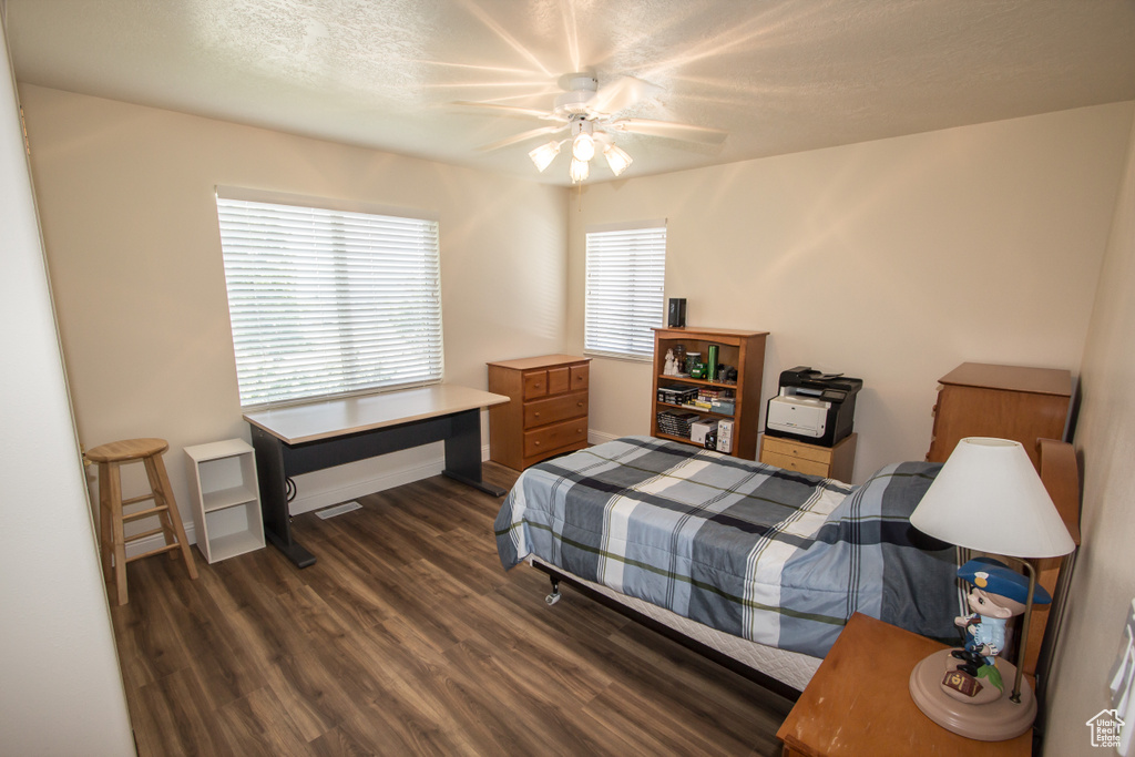 Bedroom featuring wood finished floors, ceiling fan, a textured ceiling, and an office area