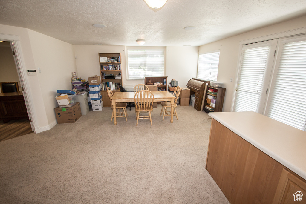 Dining space featuring a textured ceiling and light carpet