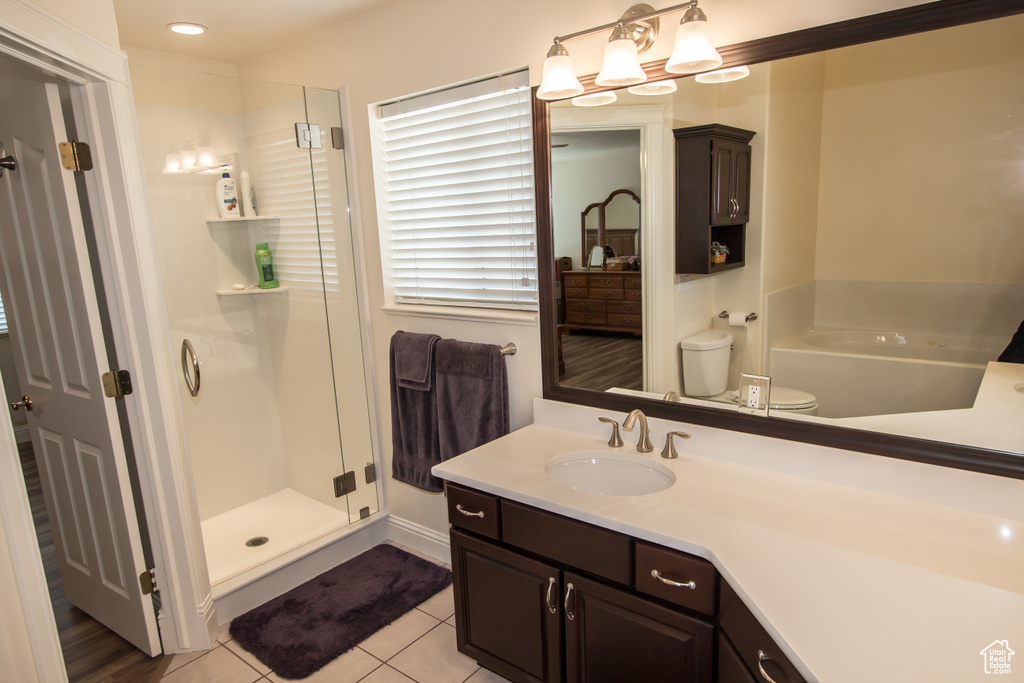 Full bath featuring vanity, a stall shower, tile patterned flooring, toilet, and a bath