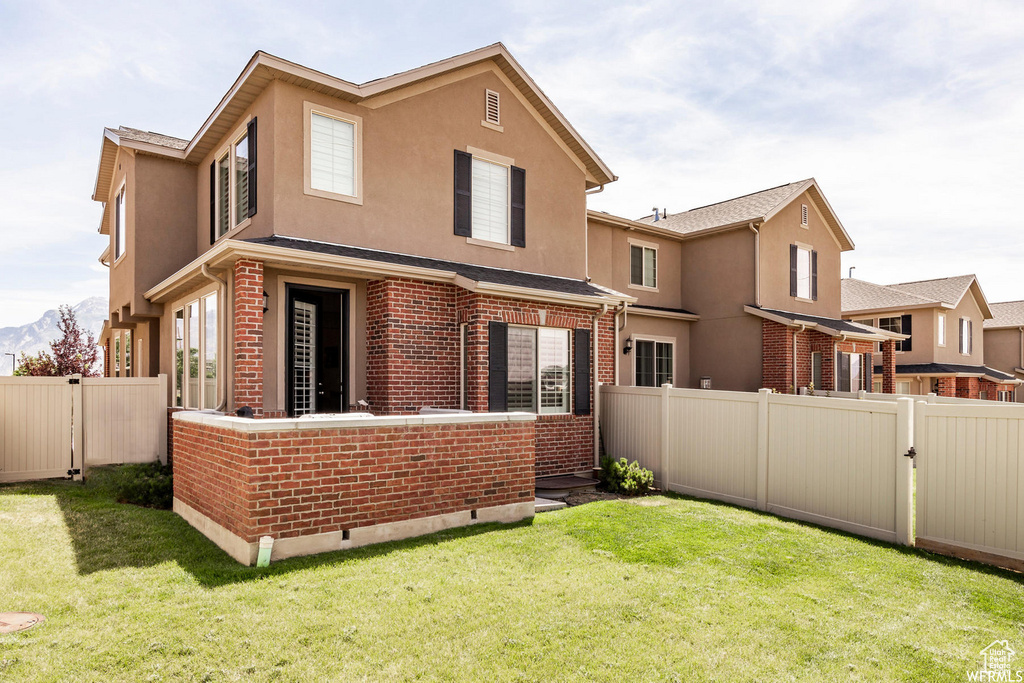 Back of property with stucco siding, brick siding, a gate, and crawl space