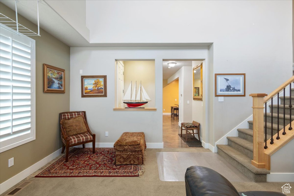 Living area featuring stairway, carpet floors, and baseboards