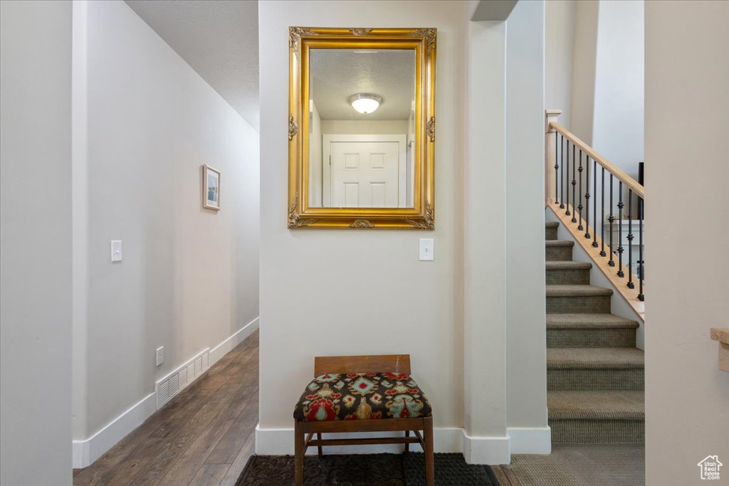 Stairway with wood finished floors and baseboards