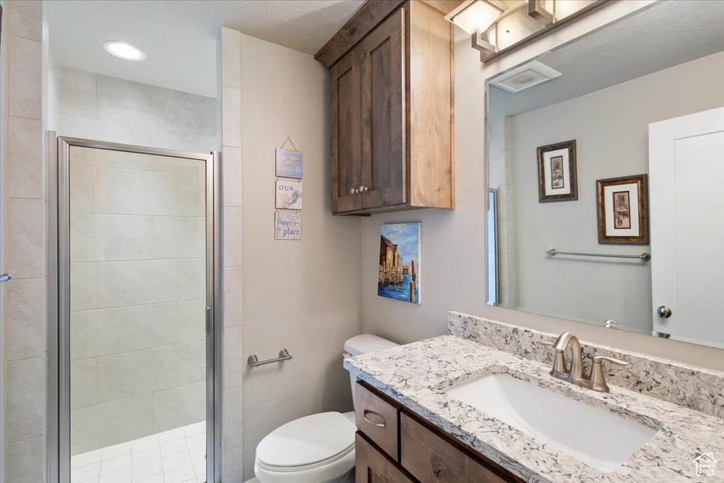 Full bathroom with vanity, toilet, and a shower stall
