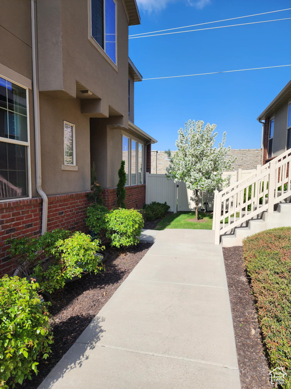 View of side of property with stucco siding, brick siding, and a patio