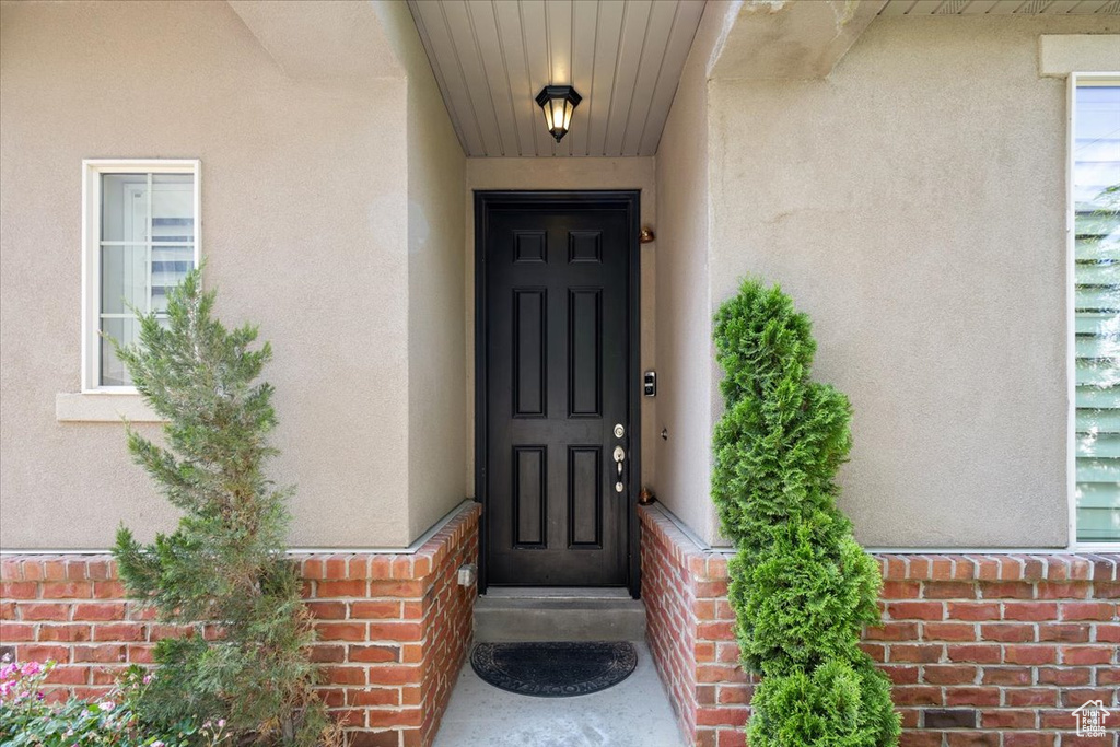 Property entrance with stucco siding and brick siding