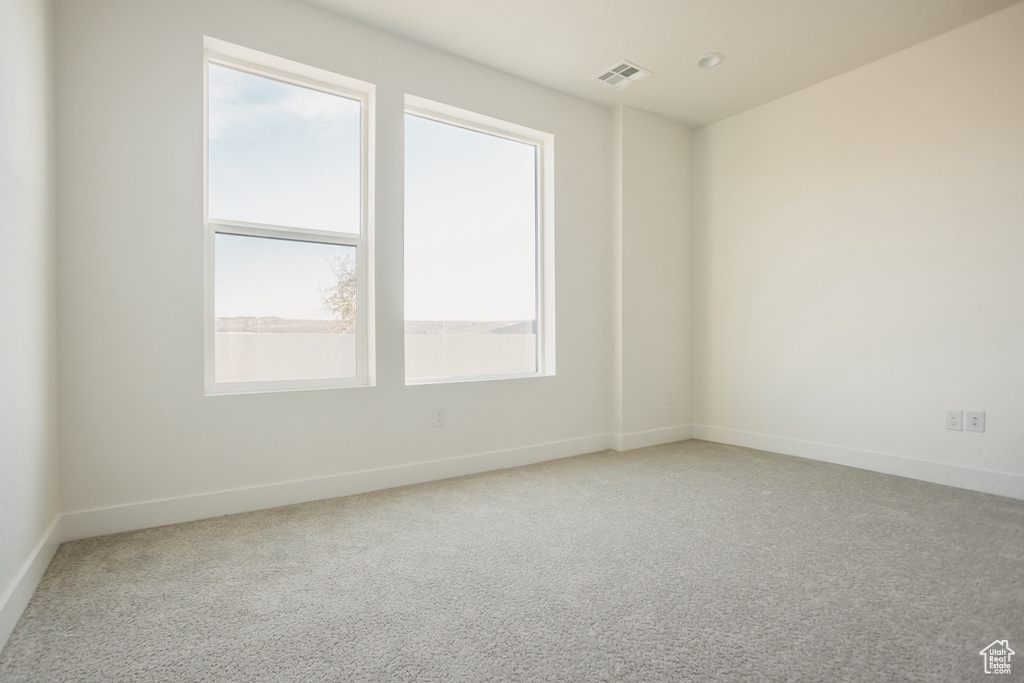 Carpeted spare room with baseboards