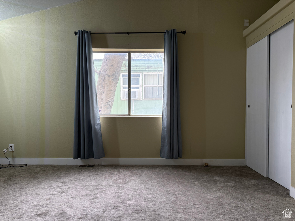 Empty room with carpet and baseboards