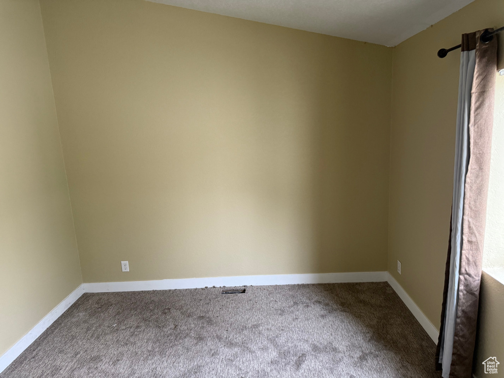 Carpeted empty room with baseboards
