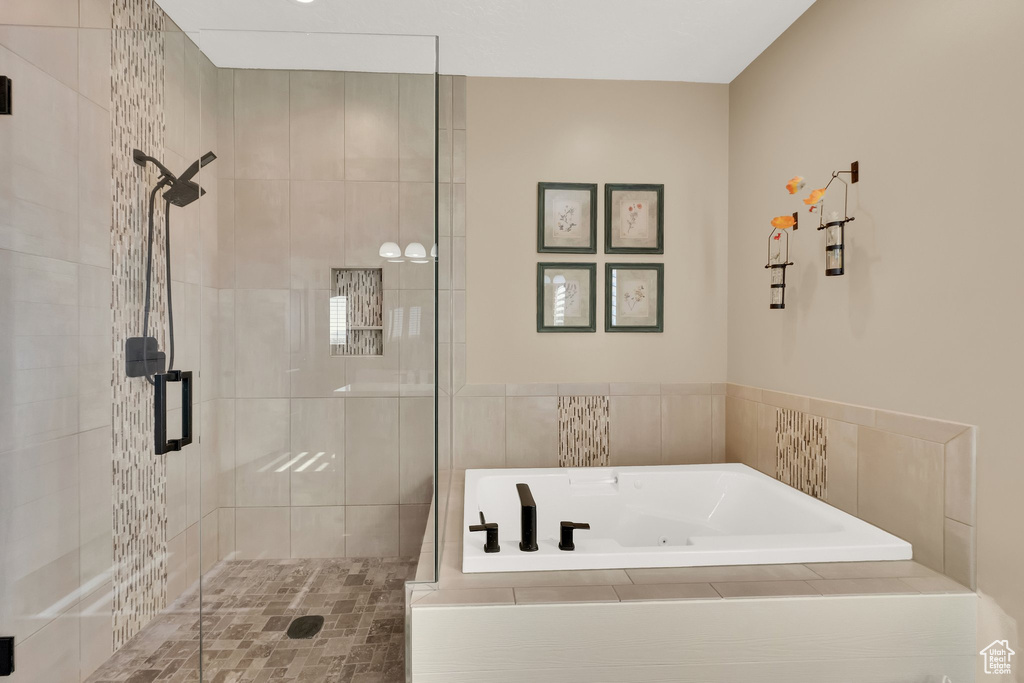 Full bath with a shower stall and a whirlpool tub