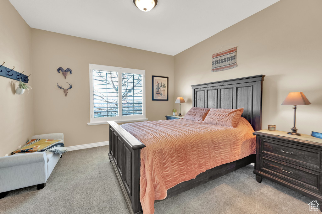 Bedroom with light colored carpet and baseboards