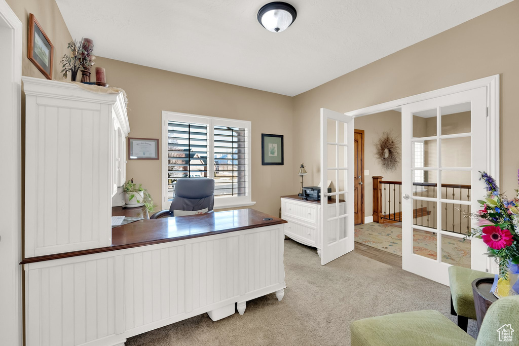 Office space with light colored carpet and french doors