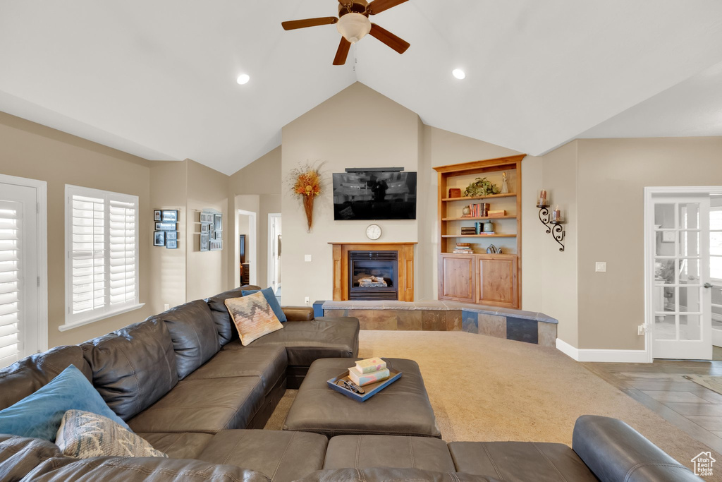 Living room featuring baseboards, ceiling fan, a glass covered fireplace, built in shelves, and recessed lighting