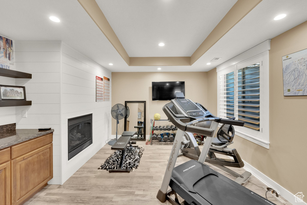 Workout area featuring a fireplace, light wood-type flooring, recessed lighting, and baseboards