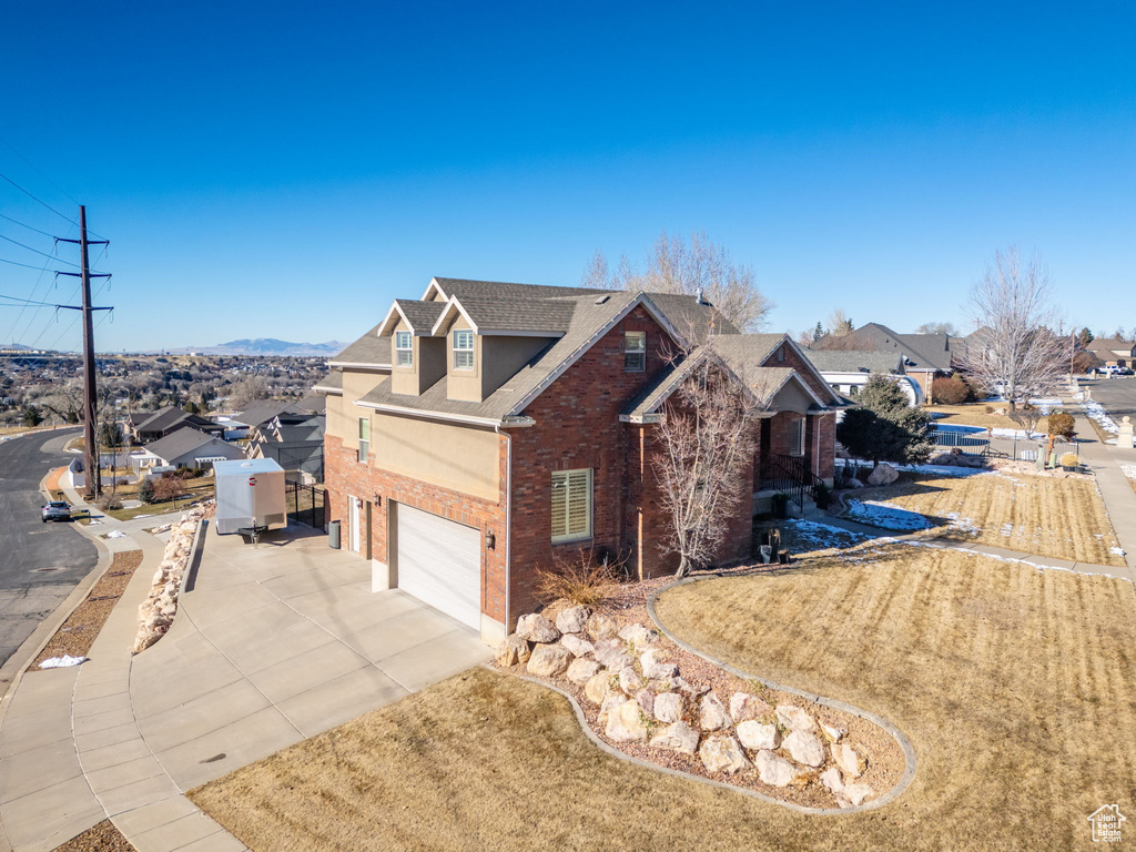 View of home\'s exterior with brick siding, concrete driveway, a garage, and roof with shingles