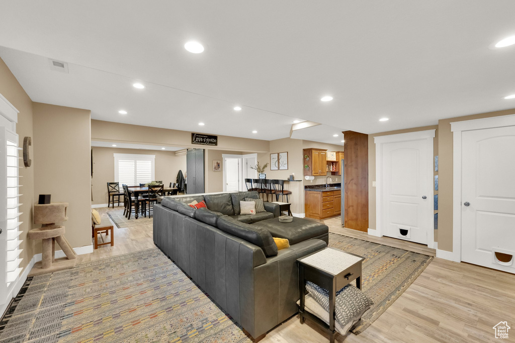 Living room with light wood-type flooring, baseboards, and recessed lighting