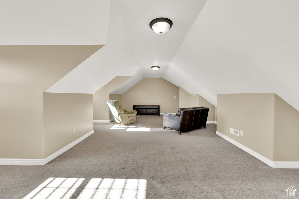 Bonus room featuring carpet flooring, vaulted ceiling, and baseboards
