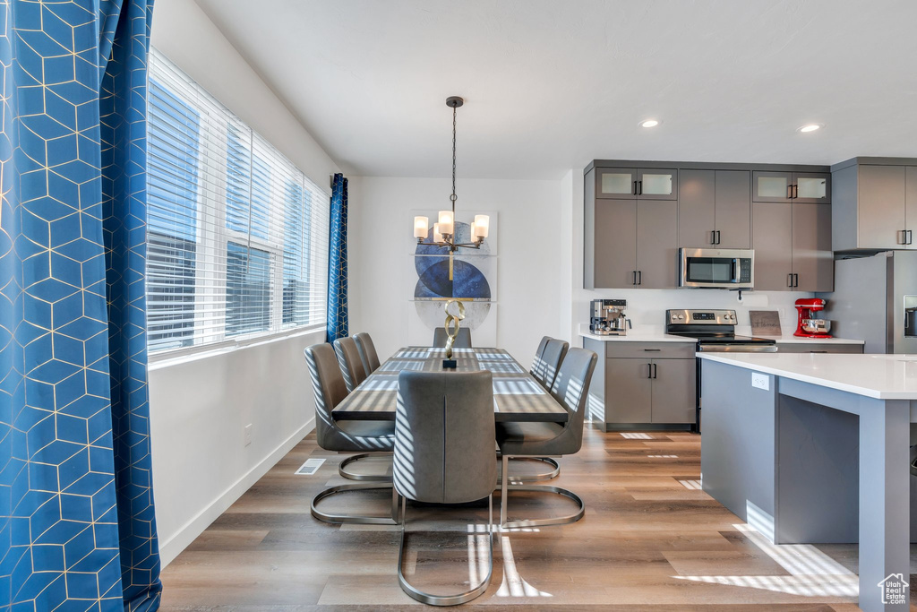 Dining space featuring a chandelier, wood finished floors, recessed lighting, and baseboards