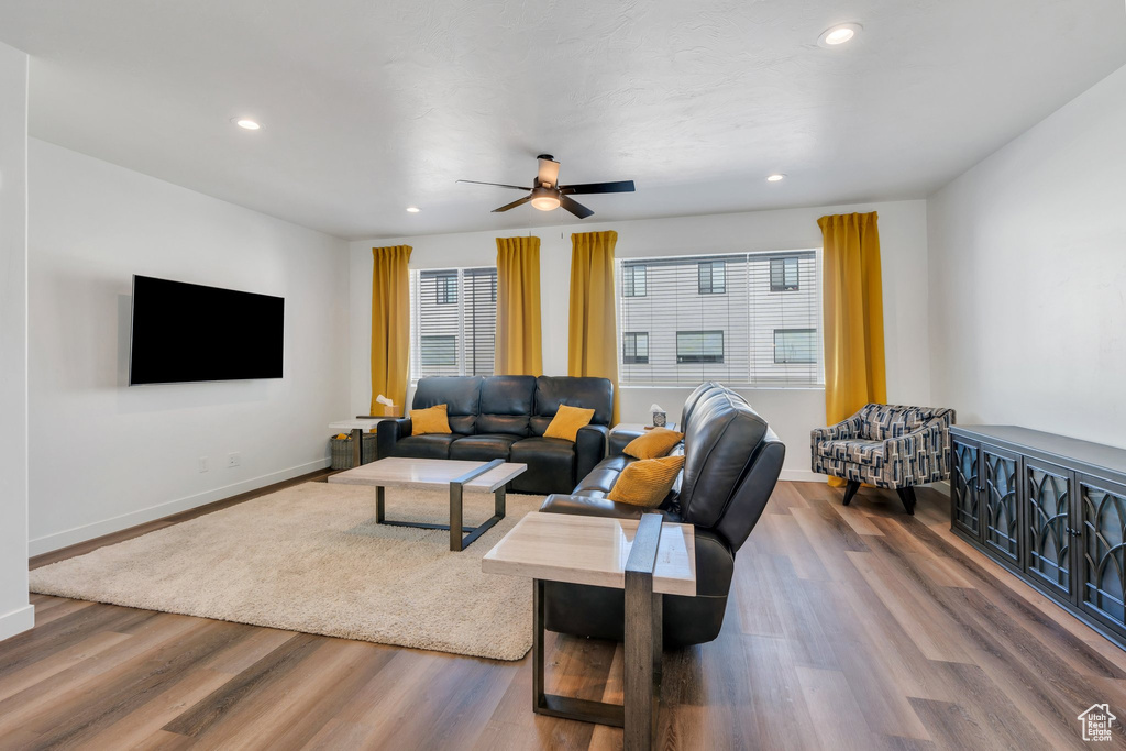 Living area featuring healthy amount of natural light, ceiling fan, wood finished floors, baseboards, and recessed lighting