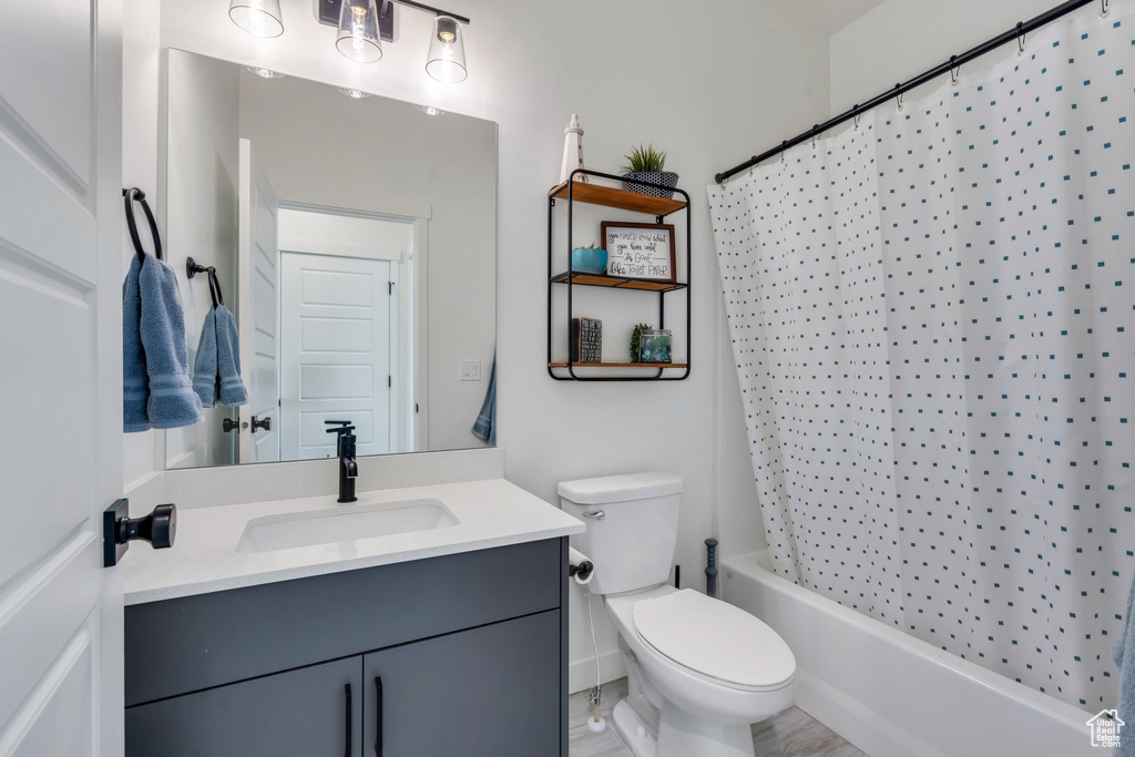 Bathroom featuring vanity, toilet, and shower / tub combo