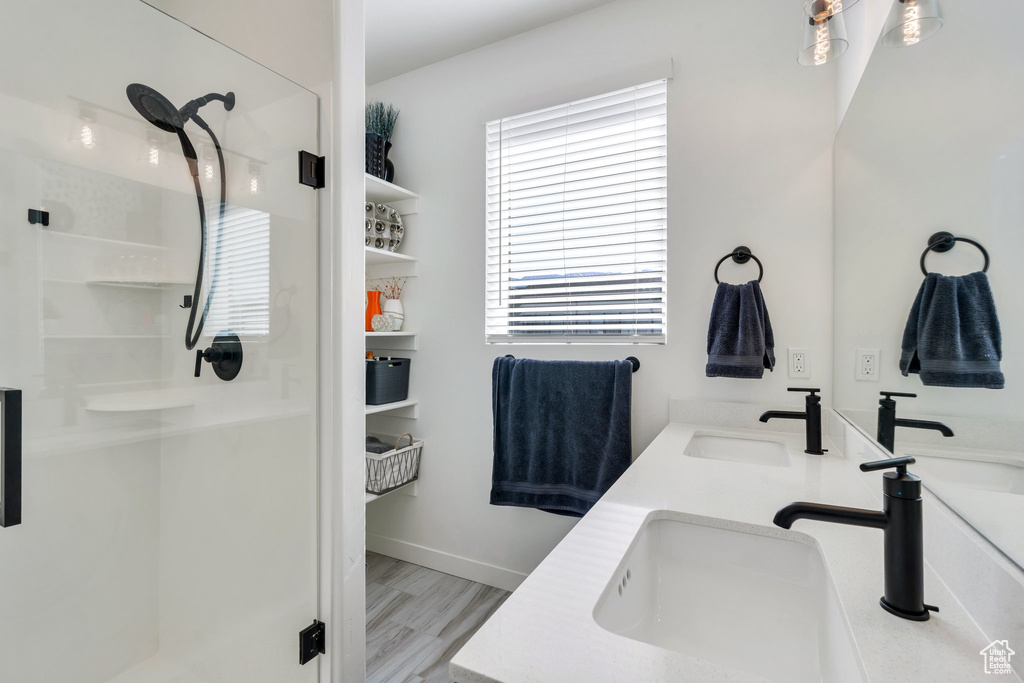 Full bathroom with a stall shower, wood finished floors, and double vanity