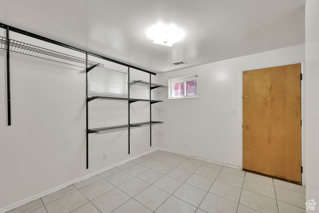 Unfurnished bedroom with light tile patterned floors and baseboards