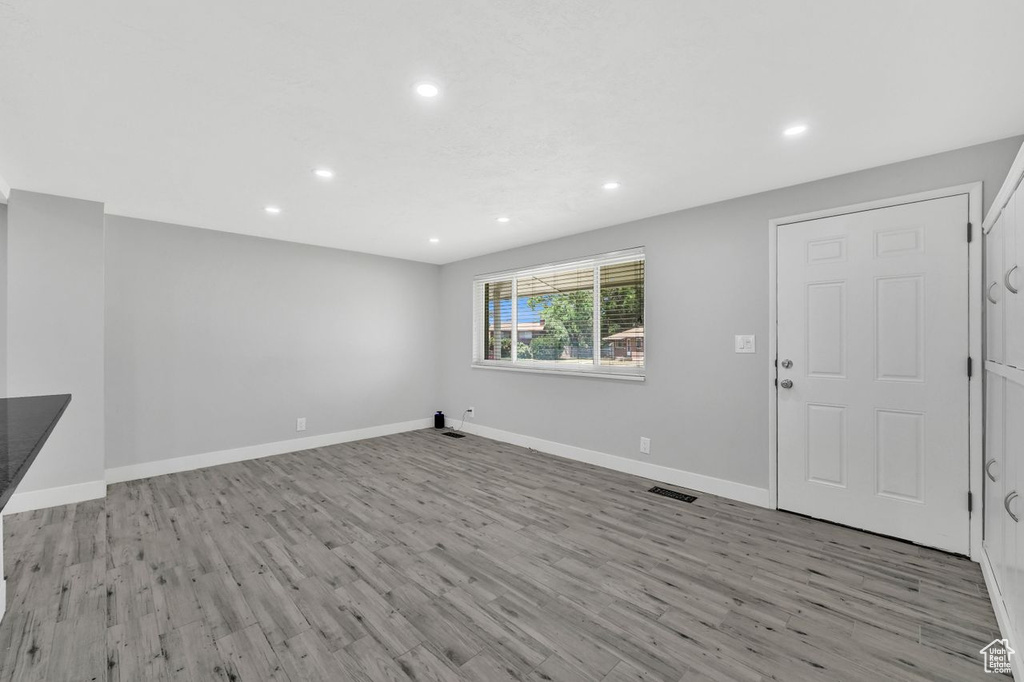 Unfurnished living room featuring recessed lighting, wood finished floors, and baseboards