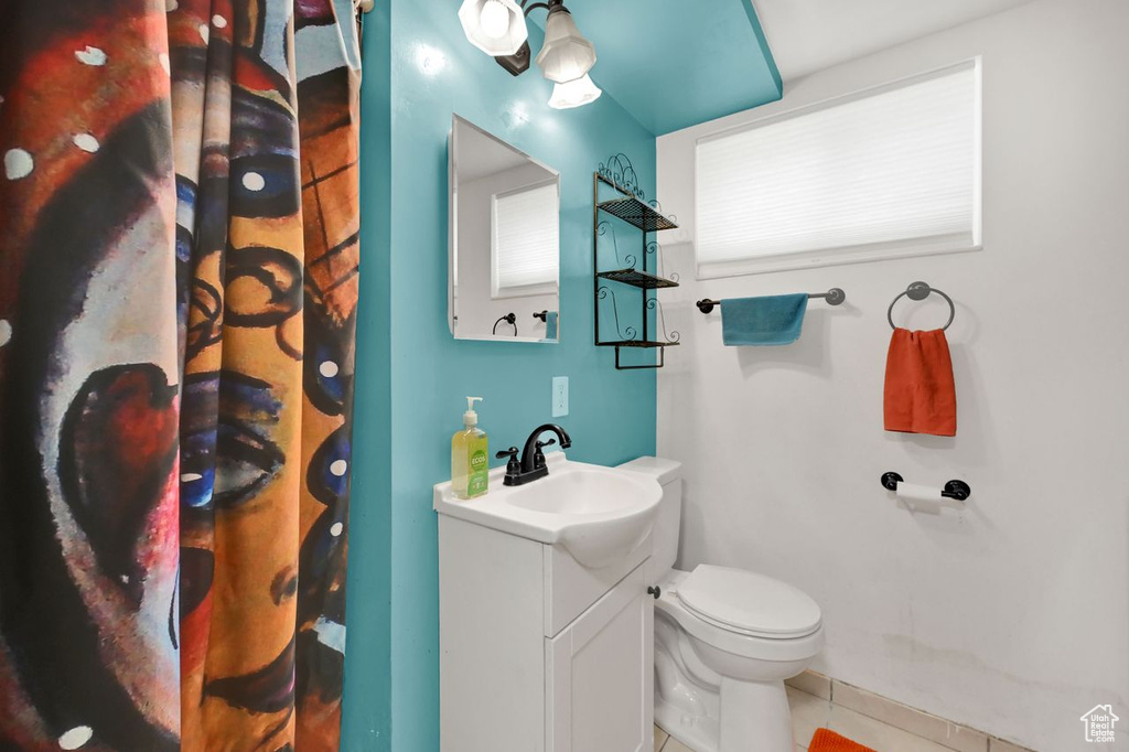 Full bath with vanity, tile patterned floors, toilet, and a shower with shower curtain