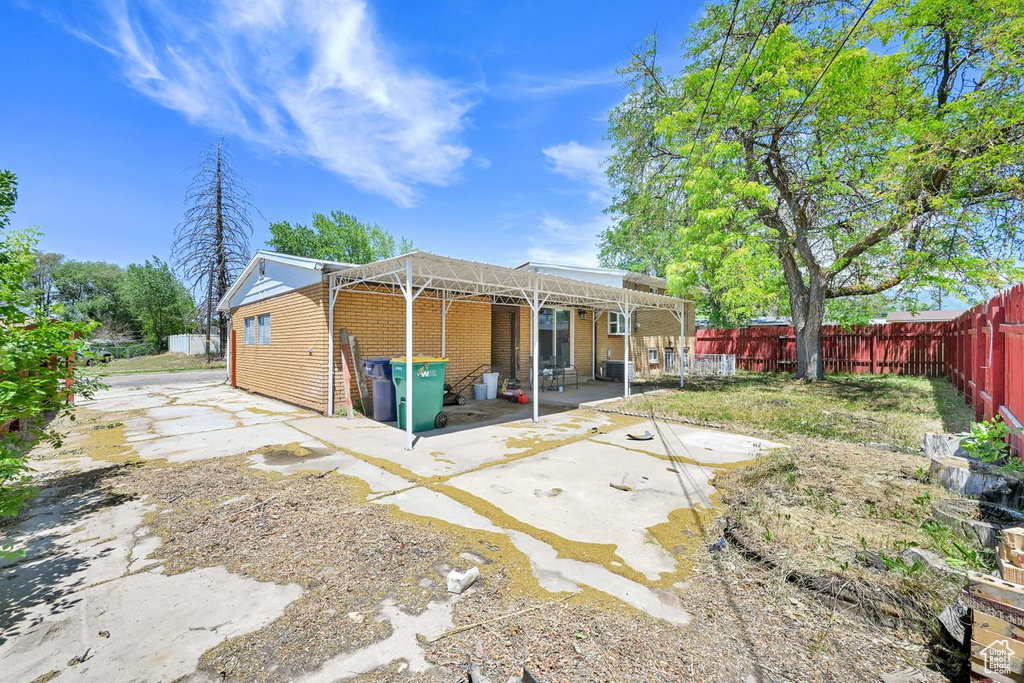Back of house featuring a patio area, brick siding, and a fenced backyard