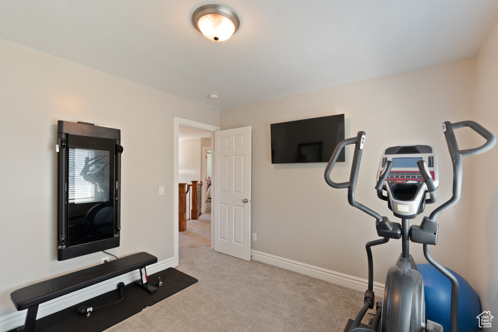 Exercise area with carpet floors and baseboards