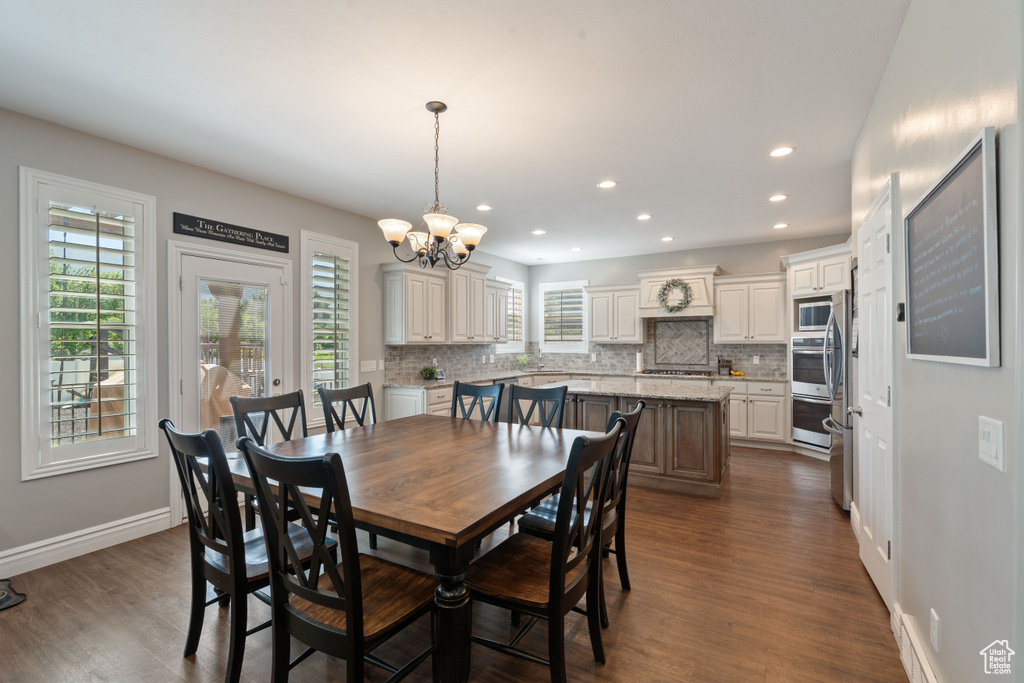 Dining space featuring dark wood-style flooring, a chandelier, recessed lighting, and baseboards