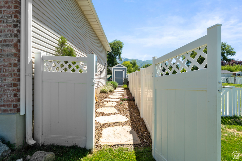 View of side of home with a mountain view and a gate