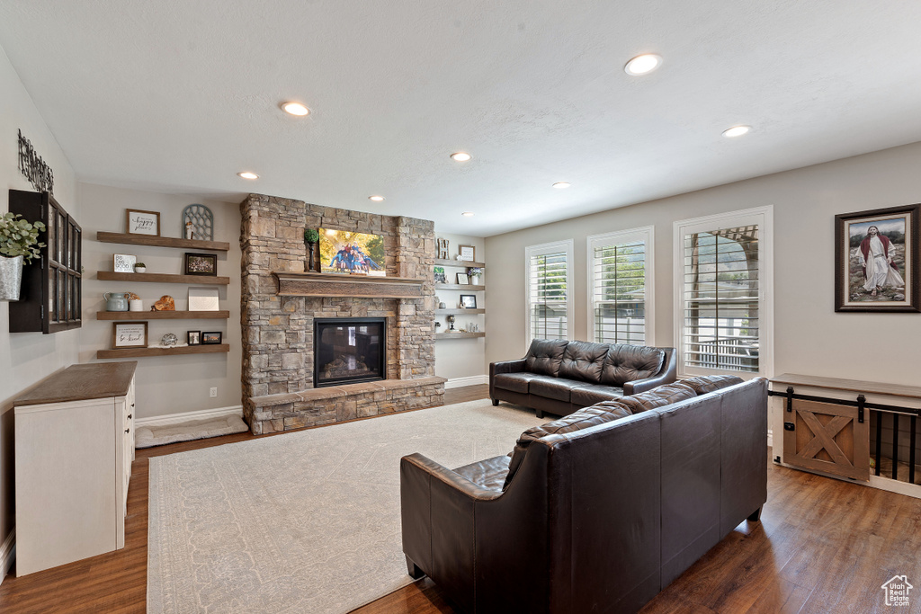 Living area with wood finished floors, a fireplace, recessed lighting, and baseboards
