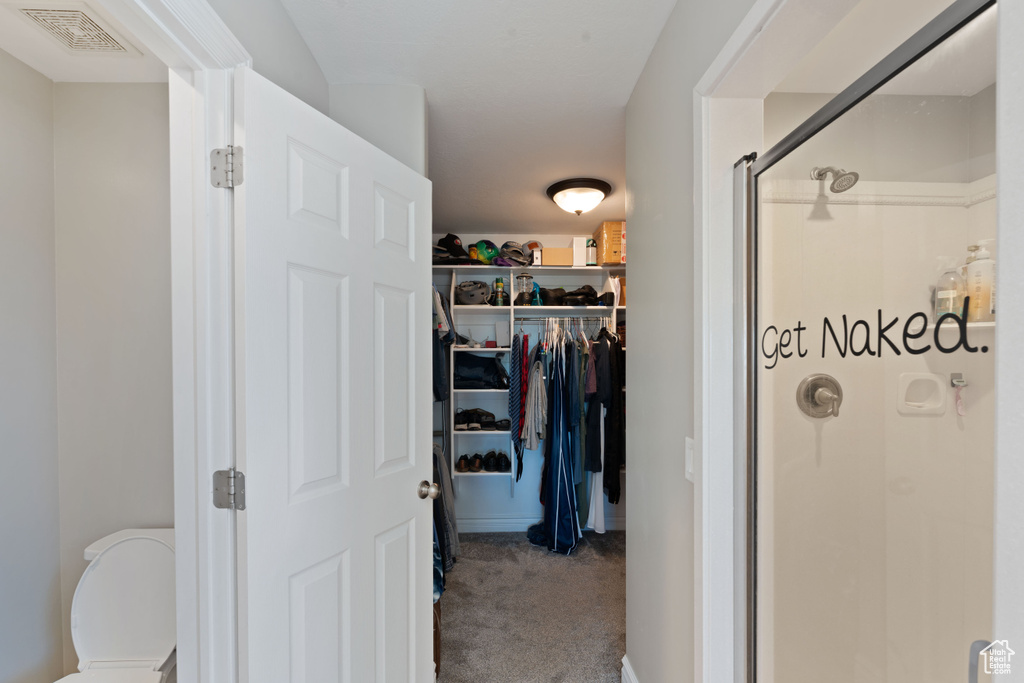 Full bathroom with a stall shower, a spacious closet, and toilet