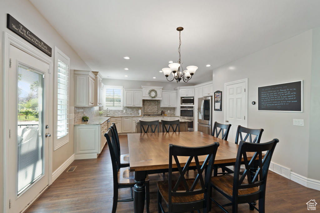 Dining space featuring a chandelier, dark wood-type flooring, recessed lighting, and baseboards
