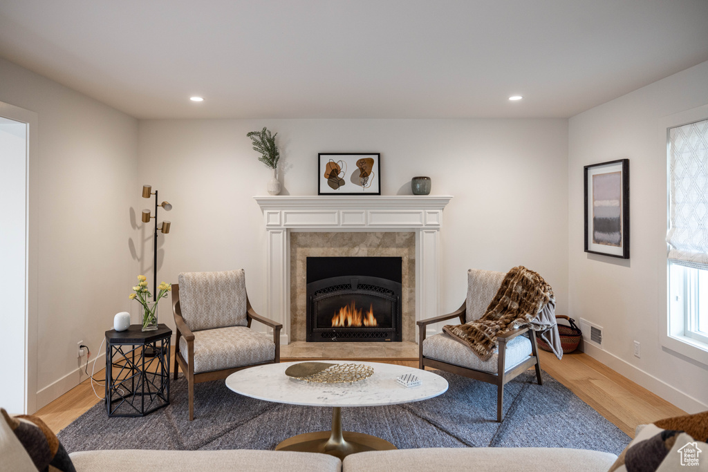 Sitting room with a premium fireplace and light hardwood / wood-style flooring