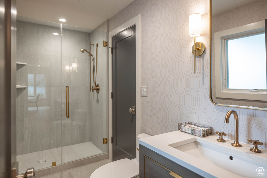 Bathroom with vanity, an enclosed shower, and toilet