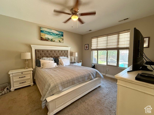 Carpeted bedroom with baseboards and a ceiling fan