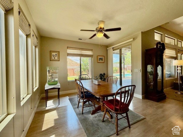 Dining room with wood finished floors, ceiling fan, and baseboards